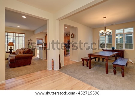 Open floor plan. View of dining room with Carved wooden table, living room with brown sofa and kitchen