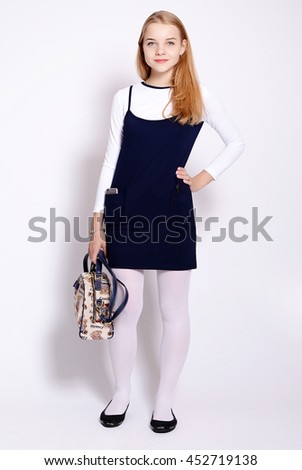Beautiful young school girl advertises school uniforms.Isolated studio portrait