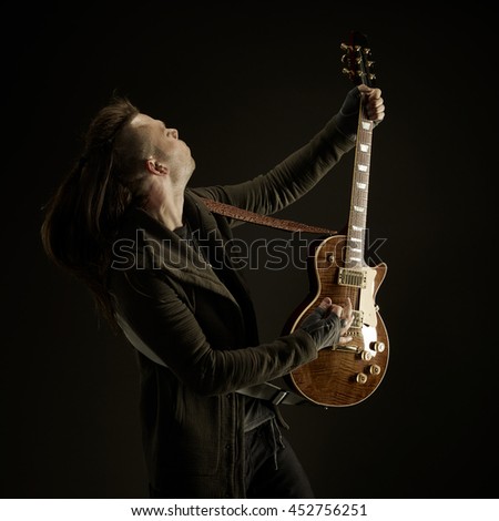 The guitarist plays solo. Close-up. Dark background