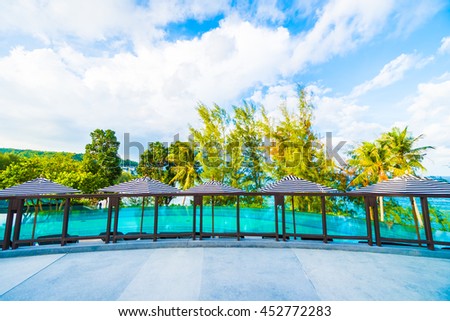 Beautiful luxury outdoor swimming pool in hotel resort with umbrella and chair on blue sky neary sea and ocean - Holiday vacation concept for background