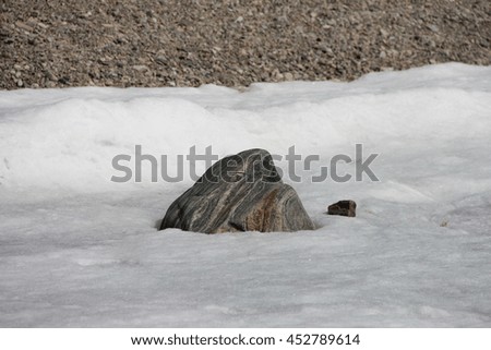 Big light gray stone in the ice. Picture taken at Lake Baikal, Russia.