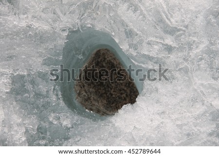 Light gray stone in the ice. Picture taken at Lake Baikal, Russia.
