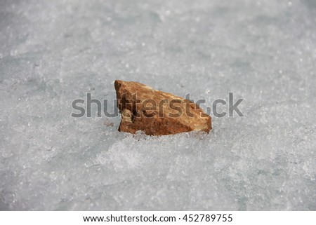 Brown stone in the ice. Picture taken at Lake Baikal, Russia.