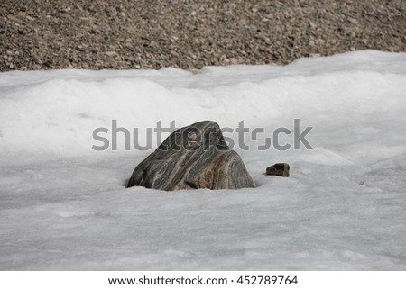 Big light gray stone in the ice. Picture taken at Lake Baikal, Russia.