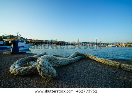 Marine rope on the dock against sea water and yachts background