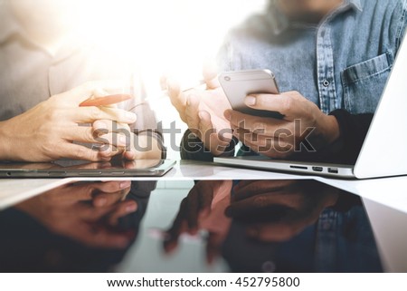 Photo website graphic designer hand working with new project modern studio. laptop digital tablet smart phone on wood table.Books papers documents. Blurred background, sun flare effect
