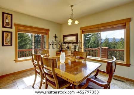 View of wooden table set with glass vase in the dining room. The room  has marble tile floor.