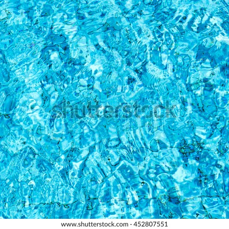 blue water wave in swimming pool reflect with sun light 
