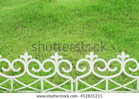 Lawn and a white plastic fence.                      