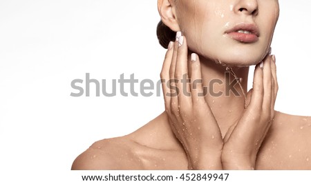 Beautiful Model Girl with splashes of water in her hands. Beautiful Smiling Woman under splash of water with fresh skin over white background. Skin care Cleansing and moisturizing concept. Beauty face Royalty-Free Stock Photo #452849947