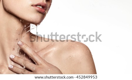 Beautiful Model Girl with splashes of water in her hands. Beautiful Smiling Woman under splash of water with fresh skin over white background. Skin care Cleansing and moisturizing concept. Beauty face Royalty-Free Stock Photo #452849953