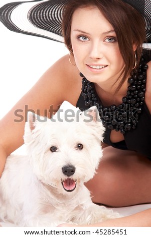 Young woman in a hat is happy to be with her little dog