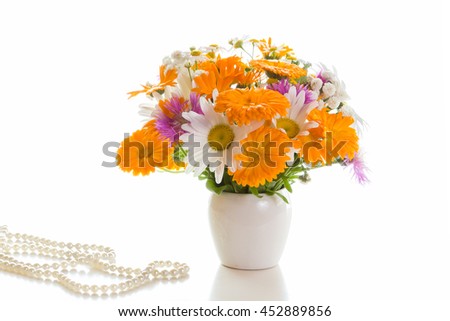 Bouquet of daisies, cornflowers, calendula in a white vase on a white background.