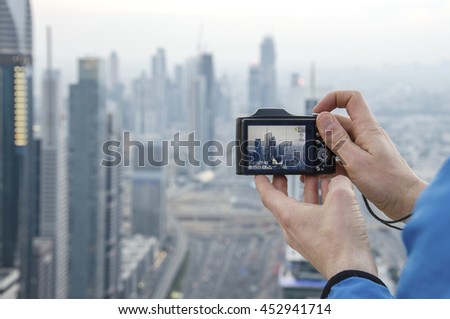 Tourist man taking a photo with his camera in Dubai, OAE