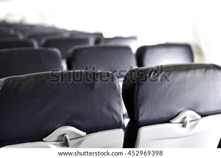 View of airline seat backs with tray and head rest Royalty-Free Stock Photo #452969398