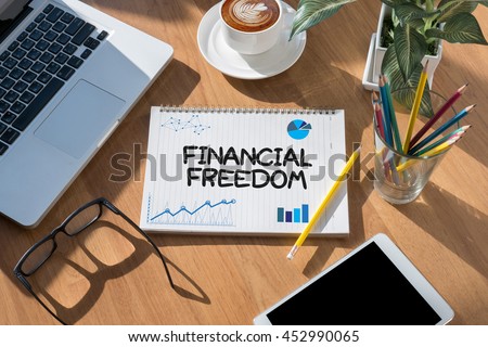 FINANCIAL FREEDOM open book on table and coffee Business Royalty-Free Stock Photo #452990065