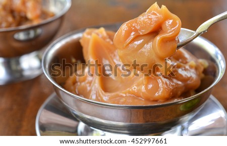 Two servings of caramel cream (doce de leite), a Brazilian desert, from the side, on wooden background Royalty-Free Stock Photo #452997661