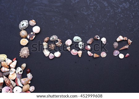 The word peace written with seashells against a black background