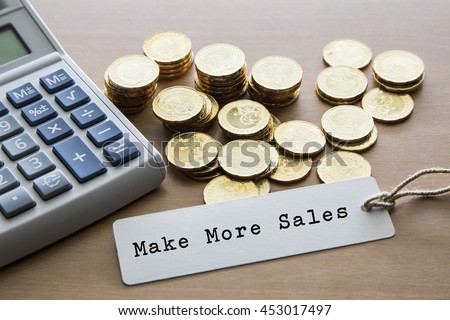 Make more sales word on tag label with calculator and gold coins, financial concept.