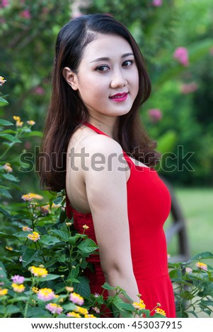 A portrait of a beautiful asian woman smiling brightly and green leaf background at the camera