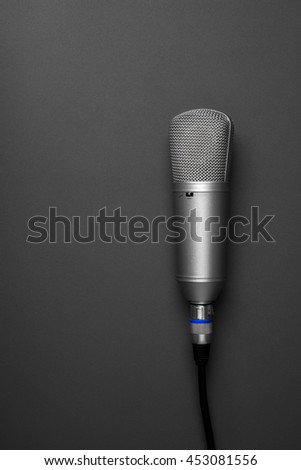 An isolated studio microphone on a grey background