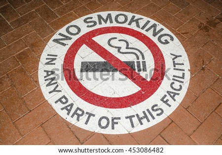 Stenciled no smoking sign in public and city walkways,parks, and pedestrian path / No Smoking / Permanent stenciled signs with striking highlight warning in red