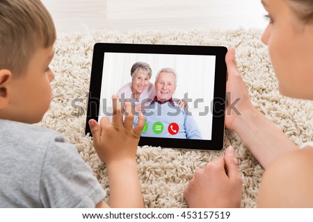 Close-up Of Mother And Son Videoconferencing On Digital Tablet At Home Royalty-Free Stock Photo #453157519