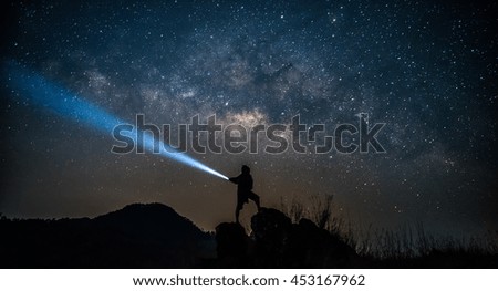 Star-catcher. A person is standing next to the Milky Way galaxy 