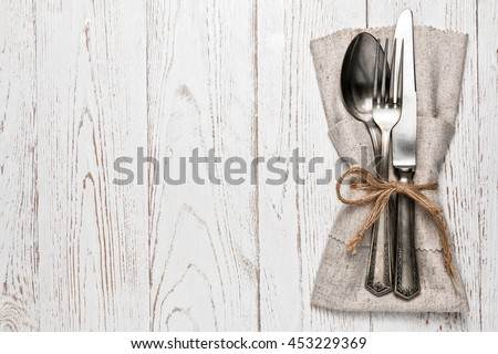 Cutlery is in a napkin wrapped on an old table Royalty-Free Stock Photo #453229369