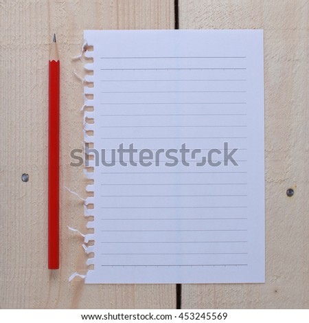 top view of empty note paper and pencil on wooden background