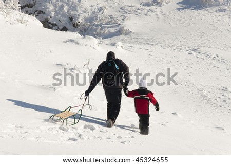 Man walking with sled. Winter sunny day.