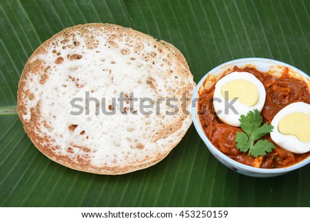 Appam / plain hoppers/ neer dosa, a popular traditional Kerala breakfast bread with hot and spicy egg roast curry on a houseboat, Alappuzha, India. South Indian food.
