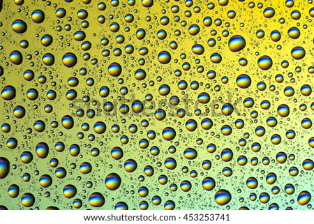 Drops of water on glass on a colored background, large