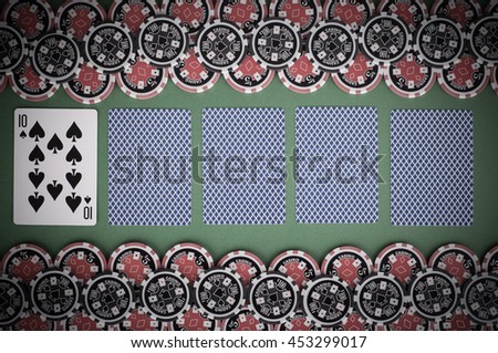 photo of top view of green casino table with ten, covered playing cards, red and black chips - vintage