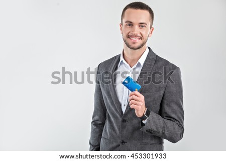 Photo of stylish handsome young man isolated on white background. Man with smart watch holding credit card