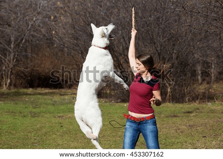 Woman playing with white dog