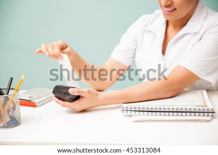 Female masseuse printing a payment receipt and smiling at a beauty spa. Closeup with some copy space