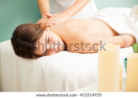 Pretty young brunette getting a back rub at a health spa and looking very relaxed