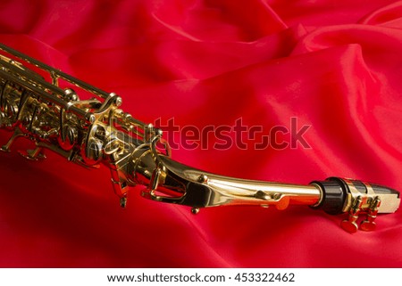 beautiful golden saxophone on delicate red silk background