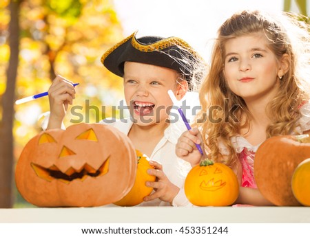 Boy and girl during Halloween crafting pumpkins