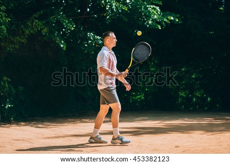 Picture of handsome young man on tennis court. Man playing tennis.