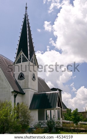 An ornate church steeple towering against a bright blue sky.