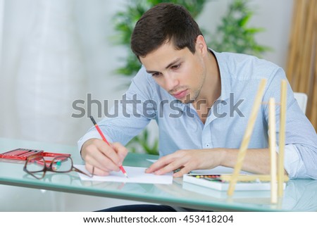 architect writing on blueprints