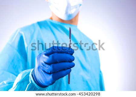 Young surgeon holding a scalpel. Ready for operation
