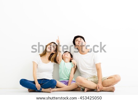 Happy  Young  Family pointing and looking up Royalty-Free Stock Photo #453425050