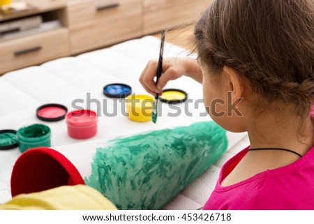 A little girl painting her school cornet
