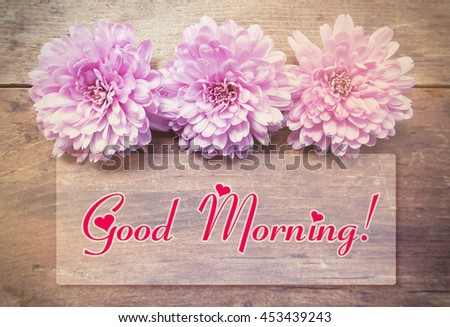 pink flowers on wooden table with Good morning