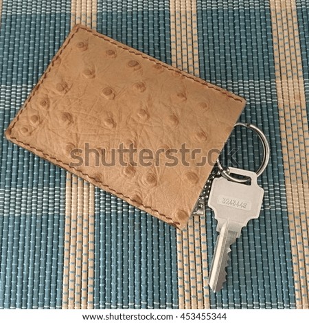 Key with leather bag on mat background