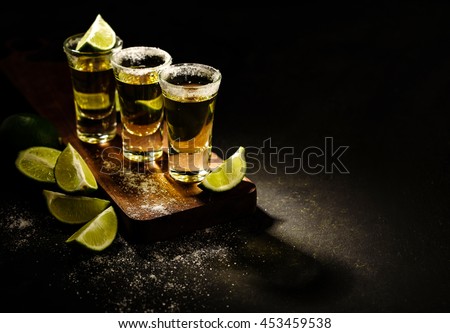 Mexican Gold Tequila with lime and salt on wooden table, selective focus. Copyspace. Royalty-Free Stock Photo #453459538