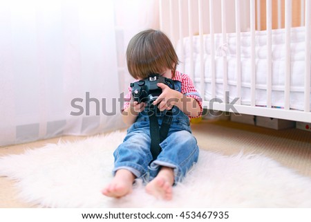 lovely little boy with digital camera at home